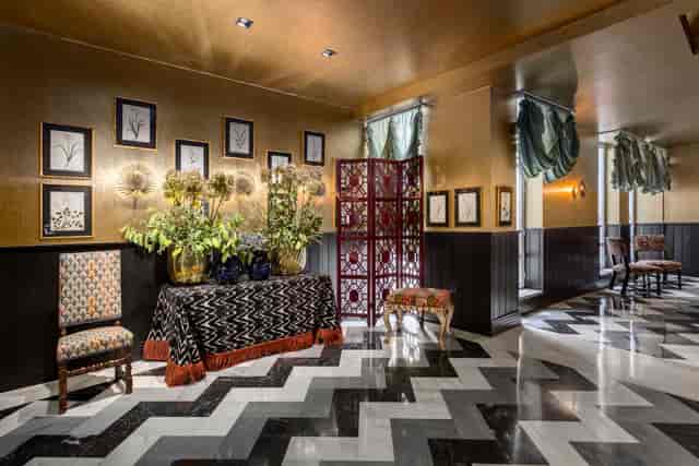 Gold lobby lounge with chevron flooring, ideal for VIP event registration and networking spaces.