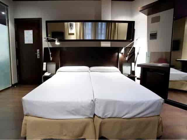 Twin-bedded hotel room at Avenida Gran Via for business travel and conference accommodation.