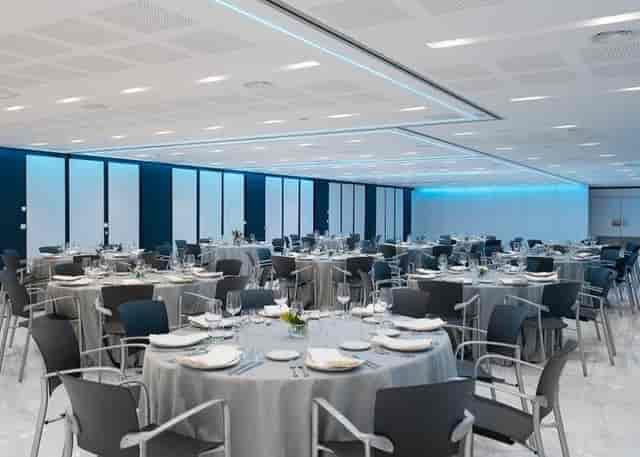 Modern Vincci Hoteles ballroom with blue lighting for corporate galas and conferences.