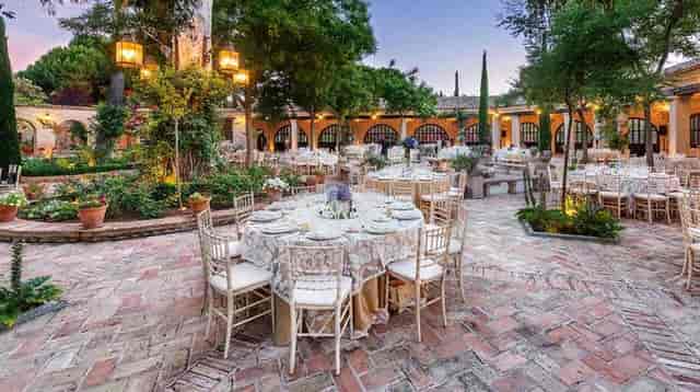 Luxury banquet setup at Jardín de Agalén with ambient lighting for corporate gala or social event.