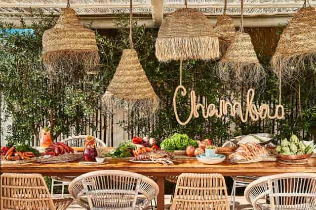 Bohemian-chic al fresco luncheon at Chambao Ibiza: luxury event setup with rustic organic decor.