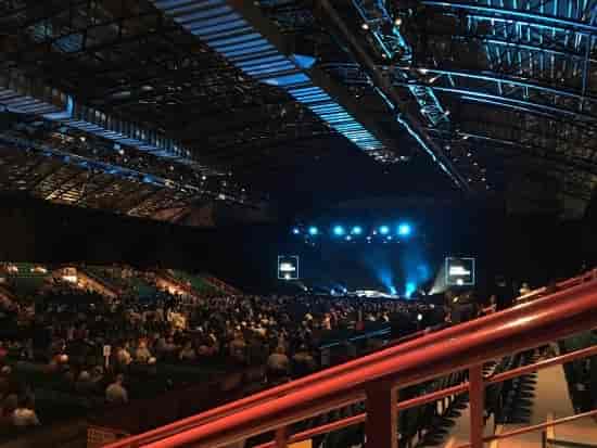 General session at Utilita Arena with dual IMAG screens and stage lighting for corporate events.