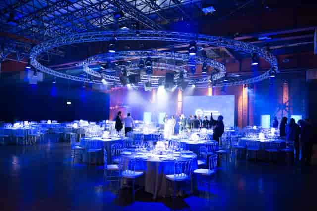 Gala banquet at Grand Milan Mecenate with circular truss lighting for industrial event venue.