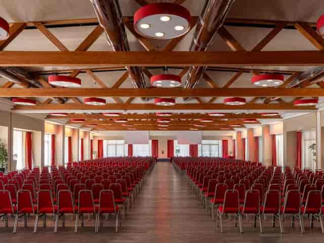 Theater-style conference room at Fiera Milano with exposed timber beams for corporate events.