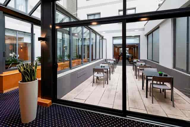 Light-filled atrium breakout space at CityLife Hotel Poliziano for corporate events and networking.