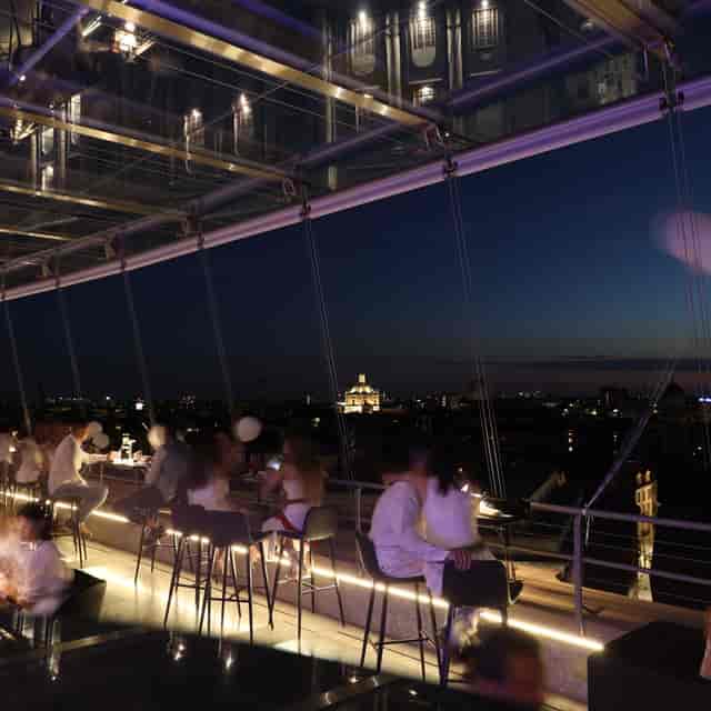 Rooftop networking event in Milan with panoramic skyline views and sophisticated lighting.