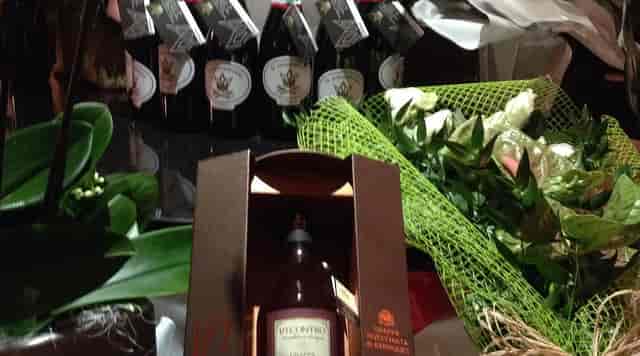 VIP gift station with premium grappa and floral decor for gala or luxury corporate incentive events.