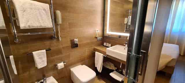 Modern hotel bathroom with illuminated mirror in Starhotels E.c.h.o. for business travel event.