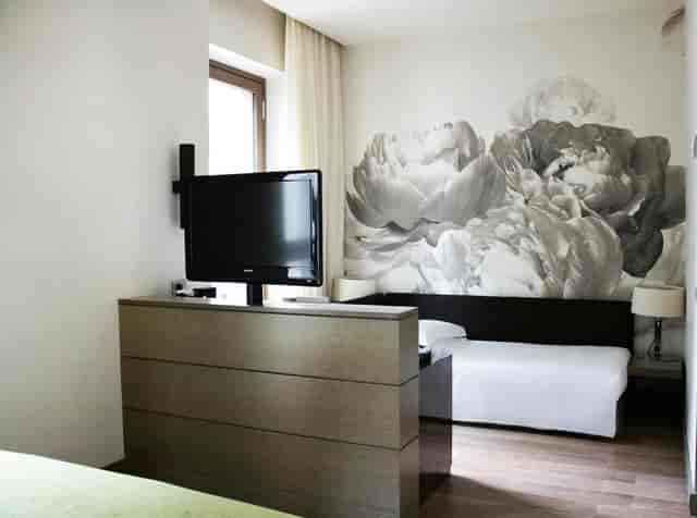 Modern hotel room with floral accent wall, perfect for boutique business travel.