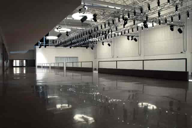 Industrial-chic foyer venue at La Pelota with overhead rigging for production and events.