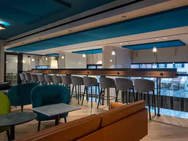 Modern meeting room with communal workspace at Urban Cube Milano for corporate networking events.