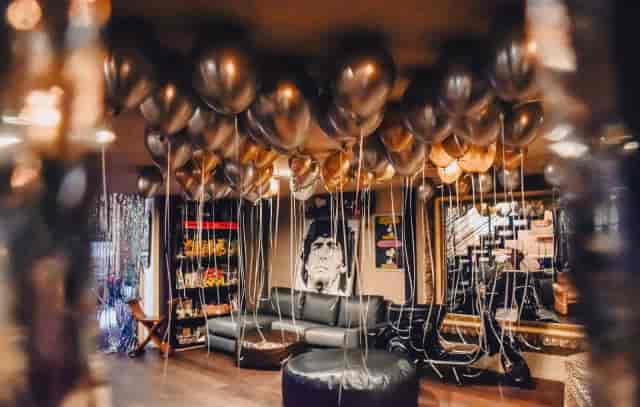 Industrial loft venue with metallic balloon ceiling for intimate event and party decoration.
