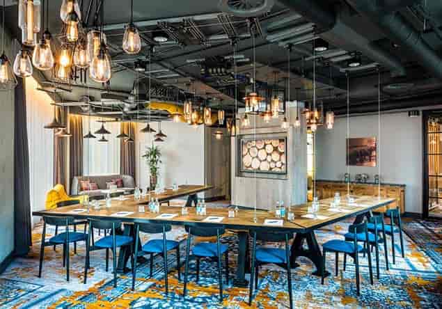 U-shaped boardroom meeting room with industrial lighting for corporate workshops and conferences.