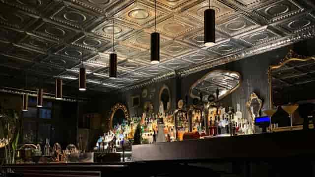 Atmospheric Open Milano cocktail bar with tin ceiling for corporate events and evening receptions.