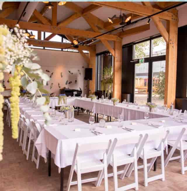 U-shape banquet setup at The Beach House, Strand-Zuid; rustic-industrial event dinner venue.