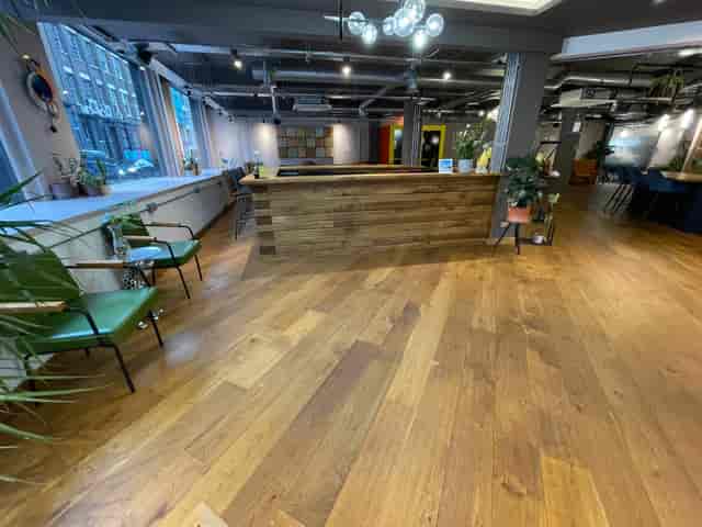 Industrial breakout space at The Lower Deck with wooden bar for networking and event registration.