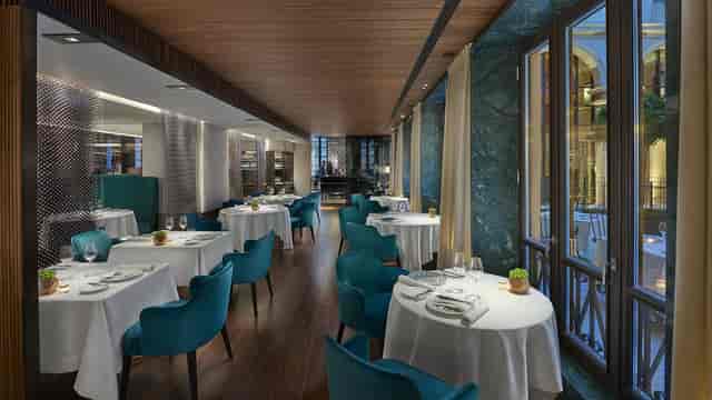 Sophisticated teal-accented banquet hall in Milan for corporate dinners and high-end board meetings.