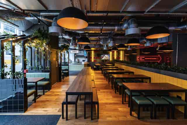 Main Hall in Market Place St Pauls with long tables, ideal for networking and corporate events.