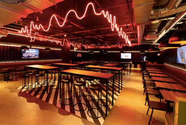 Industrial-chic event venue with neon lighting for corporate mixers and networking.