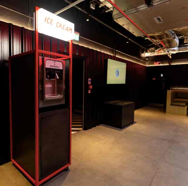 Industrial breakout area with beverage station for corporate events and networking spaces.