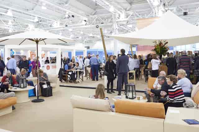 West Hall in Olympia: bustling event space with lounge seating for networking and engagement.