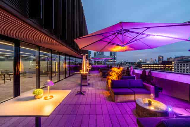 Stylish rooftop summer party venue with city skyline, perfect for networking events.