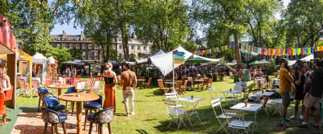 Outdoor summer party with bistro seating and festive bunting at Cocktails in the City event.
