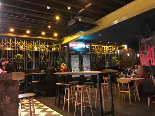 Industrial-chic bar with high-top tables for networking and casual event breakout sessions.
