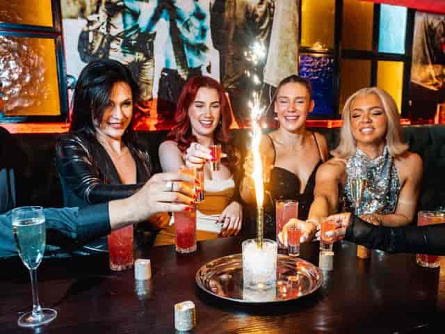 VIP sparkler bottle service at high-energy nightclub event drinks table.
