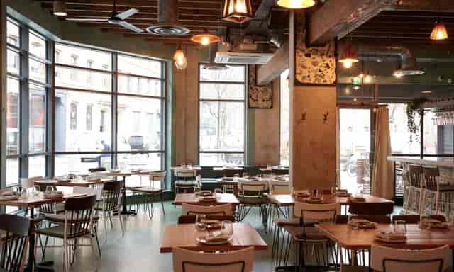 Industrial-chic event venue with high ceilings, perfect for corporate networking and mixers.