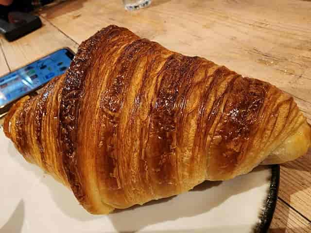 Laminated croissant at a Green Quarter Manchester cafe, perfect for a breakfast or coffee break.