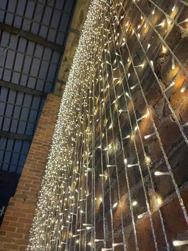 LED curtain lighting in The Barn at Morleys Hall industrial-chic wedding venue courtyard.