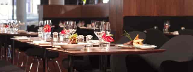 Podium Restaurant gala setup featuring elegant table settings for corporate business events.