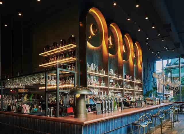 The Alchemist cocktail bar with arched shelving for networking reception and upscale event venue.