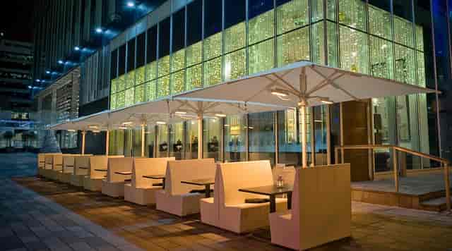 Upscale outdoor lounge with booth seating for evening networking and corporate reception events.