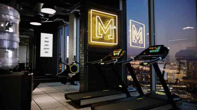 Modern hotel gym with neon branding and city views, ideal for wellness retreats and incentive travel.