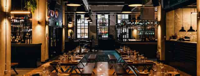 Industrial-chic bar at Exhibition MCR with communal seating for corporate mixers and events.