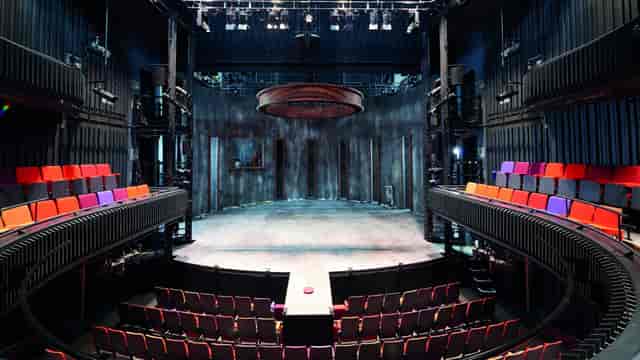 Versatile theater with circular stage and tiered seating for dynamic events.