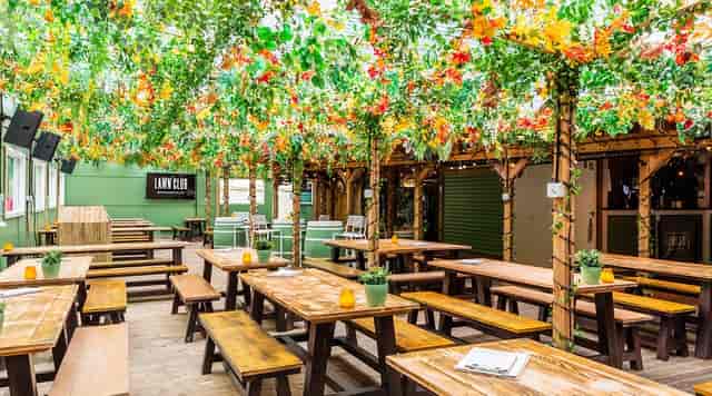 Vibrant cocktail bar with lush greenery, ideal for outdoor events and gatherings.