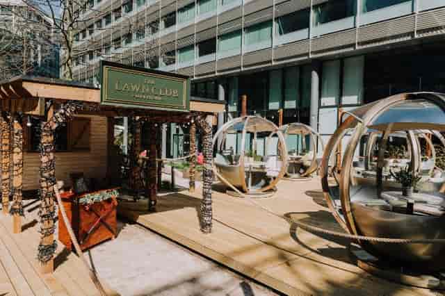 Stylish outdoor cocktail bar with spherical seating pods for networking events.