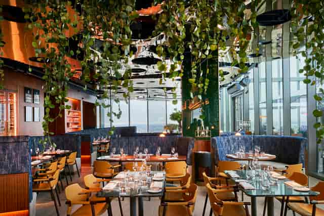 Modern private hire venue in All Bar One Manchester with lush greenery for upscale events.