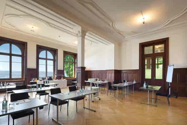 Banquet hall at Hotel Zürichberg with classroom setup for executive meetings and workshops.