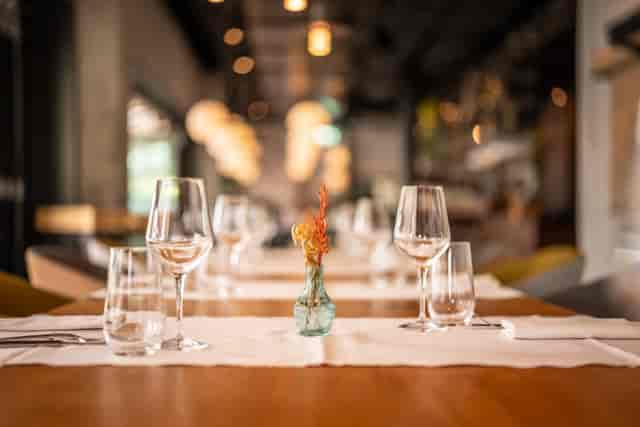 Eve’s Kitchen dining table, ambient lighting, corporate dinner setup, boutique networking event.