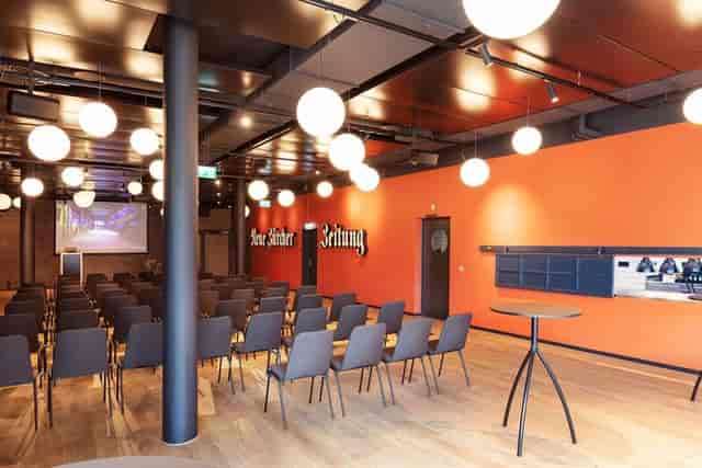 Offset at JED Events: modern theater-style meeting space with bold branding and AV setup.
