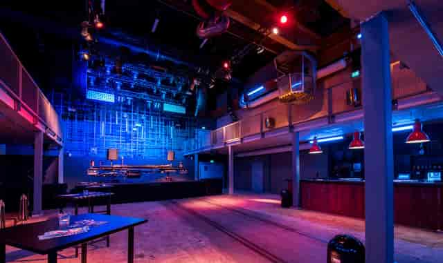 Industrial MAAG Halle venue with stage and lighting for product launches and tech mixers.