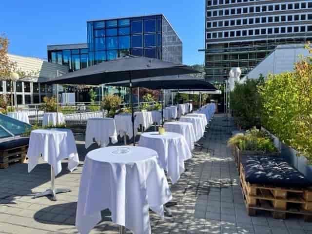 Outdoor cocktail reception at eins0eins roof terrace with high-top tables for networking events.