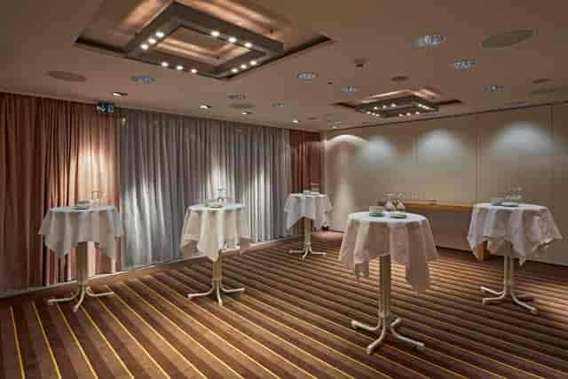 H+ Hotel Zürich meeting room with cocktail tables for professional corporate networking events.