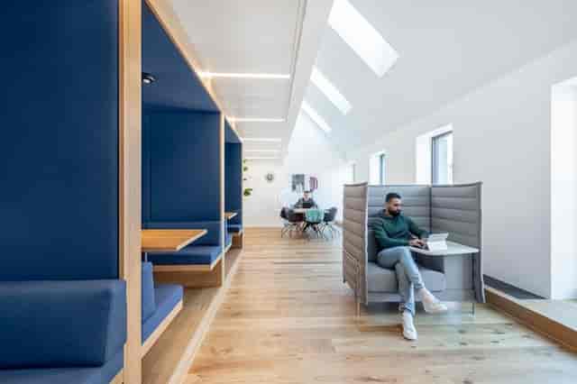 Modern hybrid coworking space with acoustic booths for focused work and professional meetings.