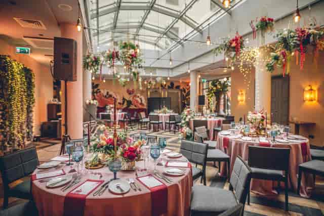 Luxury hotel bar event space with glass atrium and floral decor for gala or wedding reception.