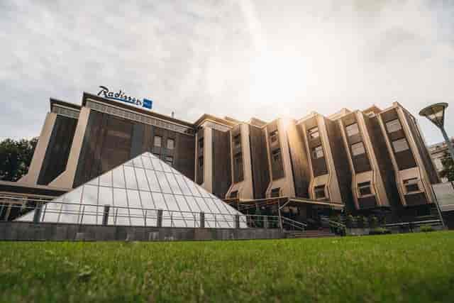 Radisson Blu Ridzene Hotel exterior with iconic pyramid for corporate events and conferences.